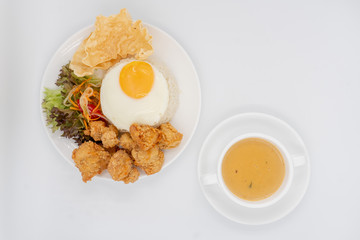 Buttermilk chicken rice with ingredients isolated on white with fried egg and salad.