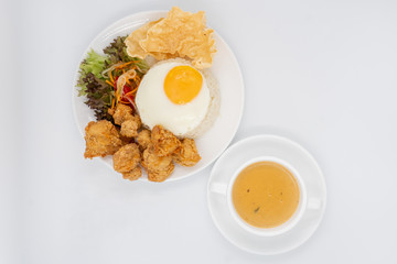 Buttermilk chicken rice with ingredients isolated on white with fried egg and salad.