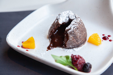 Warm dark chocolate lava cake on white plate