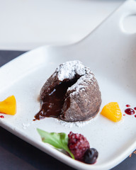Warm dark chocolate lava cake on white plate