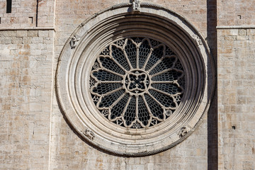 Fototapeta na wymiar Rose window of the facade of the San Vigilio Cathedral (Duomo di Trento, 1212-1321) in Romanesque and Gothic style. Trento city, Trentino-Alto Adige, Italy, Europe