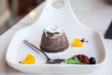 Warm dark chocolate lava cake on white plate