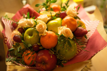 fruit and berry bouquet with roses in a package