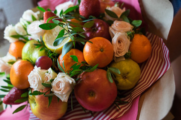 fruit and berry bouquet with roses in a package