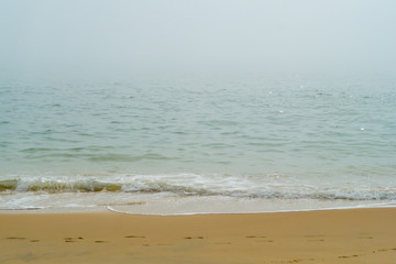 Green Sea Waves on a Yellow Beach in Spain in a Foggy Day