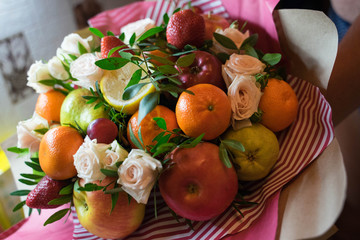 fruit and berry bouquet with roses in a package