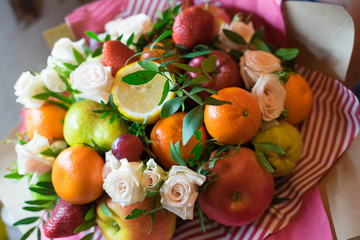 fruit and berry bouquet with roses in a package