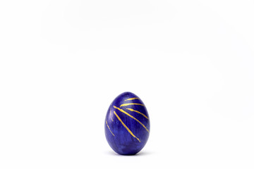 Happy Easter. One easter egg trendy colored classic blue, white and golden on white background. Copy space. Minimal style