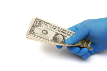 hand in blue medical glove holding dollar banknotes isolated on white background