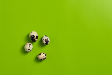 Quail eggs on green background.