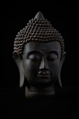 Meditating Buddha Statue isolated on black background.