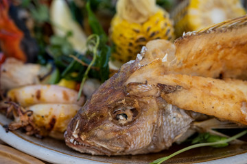 Grilled or fried whole fish with vegetables, herbs and spices