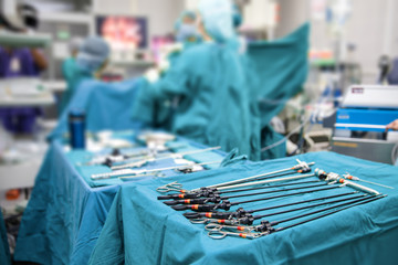 Close up of sterile table with laparoscopic tools in operating room, surgery team proceeding for a...