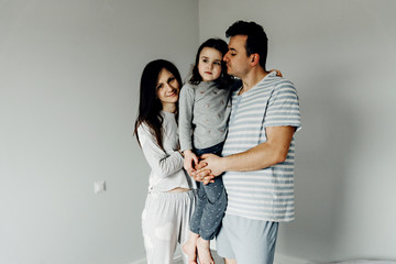 portrait of a happy family in the morning,family in pajamas,family photo,happy young family posing in pajamas at camera,dad mom and daughter take a photo as a keepsake