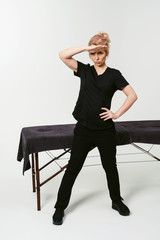 Ready to hard work! Combative mood. Portrait of young cheerful friendly woman masseur in uniforme...