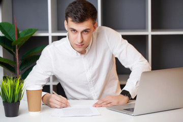 Fototapeta premium Man working at the computer in the office and filling documents