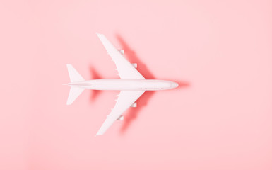 Airplane model. White plane on pink background. Travel vacation concept. Flat lay, top view, copy space