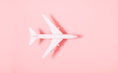 Airplane model. White plane on pink background. Travel vacation concept. Flat lay, top view, copy...