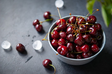 cherry berries in a plate on a dark background top view,  ice;