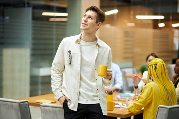 cheerful positive attractive man looking up, man never gives up. blurred background, guy looks at the bright side of life
