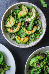 healthy salad grilled avocado and green leaves (vegetarian or diet food) menu concept background. top view. copy space for text