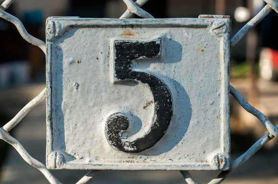 Old retro weathered cast iron plate with number 5 closeup