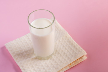 Fresh plain homemade yougurt in glass on pink background, copy space. Probiotic cold fermented dairy drink.