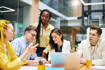 woman with yellow dreads explaining something emotionally to her colleagues, theu are listening to her very attentively, education