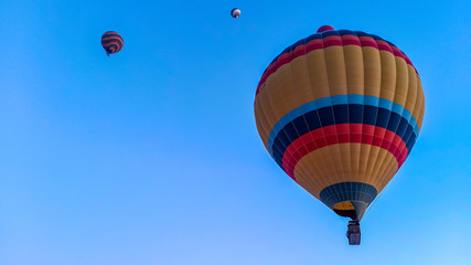 Colorful hot air balloons flying over the valley with fairy chimneys in winter season. Lots of Hot air balloons at the sunrise sky landscape in Cappadocia, Turkey
