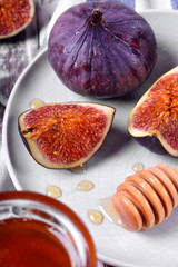 Pieces of figs drizzled with honey on white ceramic plate