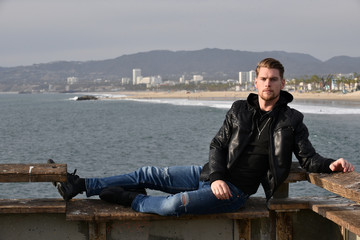 Handsome man relaxing on the pier