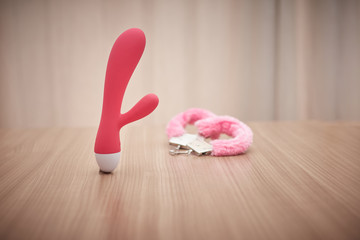 large dildo next to some pink handcuffs