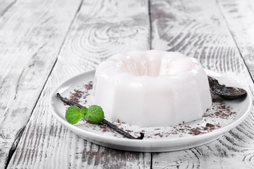 White vanilla milk jelly on ceramic plate on white wooden table