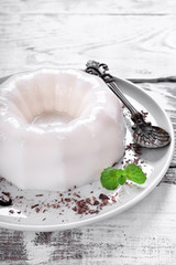 White vanilla milk jelly on ceramic plate on white wooden table