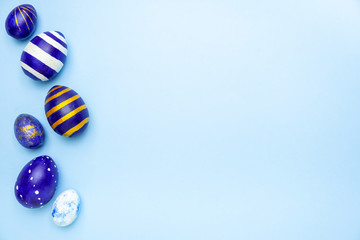 Happy Easter. Frame for text made of easter eggs trendy colored classic blue, white and golden on blue. Minimal style, top view, flatlay, copy space