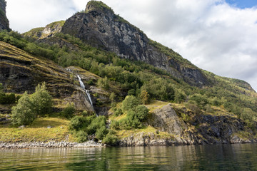 Fototapeta premium Waterfall falling in norwegian fjord Aurlandsfjord