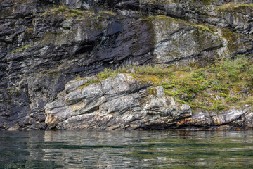 Heavy rocks water reflection in norwegian fjord