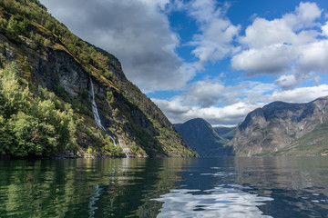 Fototapeta na wymiar Waterfall falling in norwegian fjord Aurlandsfjord