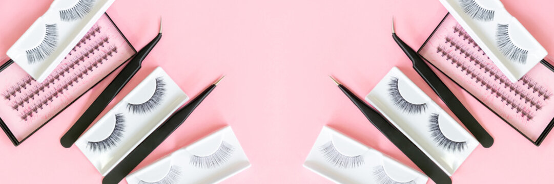 Different tools for eye lash extension on trendy pastel pink background. Fake eyelashes and tweezers. Beauty concept. Makeup cosmetics. Top view, flat lay. Layout. Place for text and design. Banner.