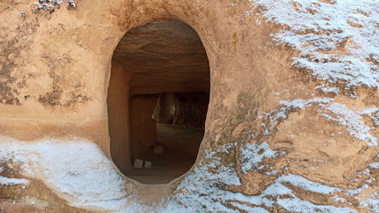 Ancient stone cave houses carved into the volcanic rock in Cappadocia, Turkey
