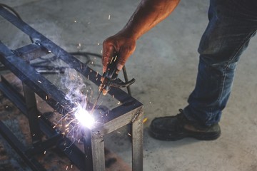 Workers are welding steel without protective gloves.