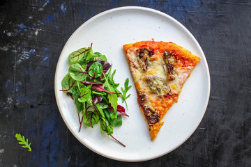 slice pizza and salad leaves in a plate on the table (tasty snack) menu concept background. top view. copy space for text