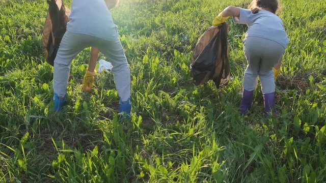 Children collect garbage in a bag.