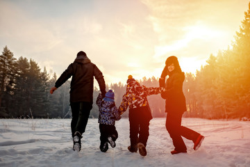 Fototapeta na wymiar family running on the snow in wintertime