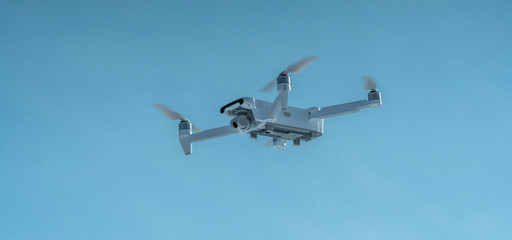 Quadrocopter drone hangs in the air. Shooting photos and videos from a height. Modern technologies of unmanned vehicles