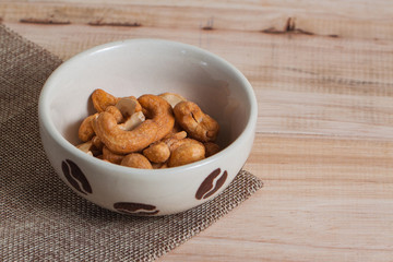 Dried Cashew Nuts food snack  organic nut with salted in the little white bowl on wood background table 