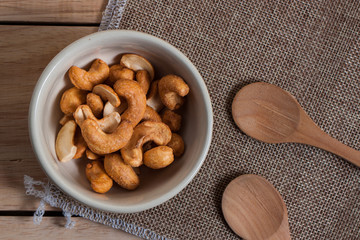 Dried Cashew Nuts food snack  organic nut with salted in the little white bowl on wood background table 