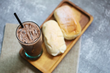 Butter bread with sugar dessert food served with iced chocolate fresh drink put on wood plate menu in coffee shop
