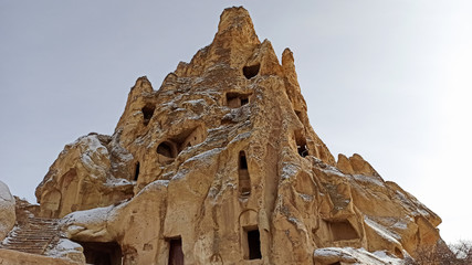Ancient stone cave houses carved into the volcanic rock in Cappadocia, Turkey