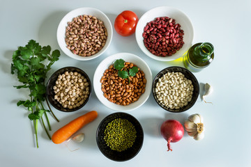 Set of products for making a recipe from legumes: phaseolus; beans; chickpeas; mung beans; tomatoes, onions, olive oil, carrots, garlic and herbs.